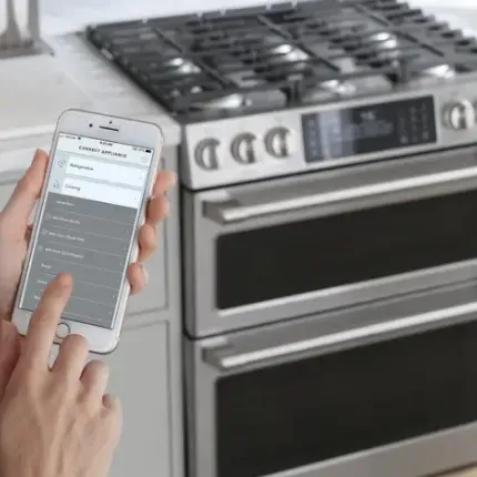 photo of an oven and someone holding a phone with features that can control the oven remotely